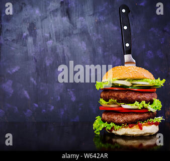 Leckere handgemachte Burger auf dunklem Hintergrund. Ansicht schließen Stockfoto