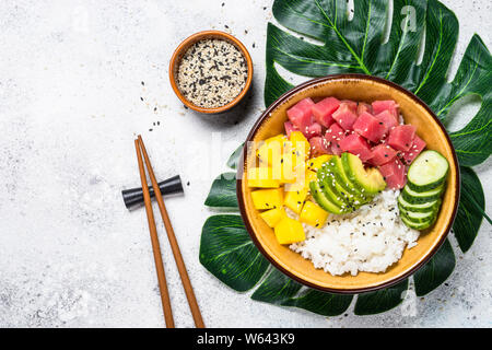 Tuna poke Schüssel mit Reis, Mango, Avocado und Gurke auf weißer Tisch. Stockfoto