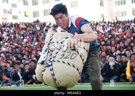 Ein Teilnehmer versucht, ein sandsack während eines starken Mannes Herausforderung in Markam County, Chamdo Stadt, im Südwesten Chinas Tibet autonomen Region, 4 Septem zu heben Stockfoto