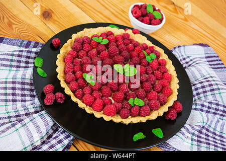 Köstliche Kuchen mit Pudding und Himbeere auf hölzernen Hintergrund Stockfoto