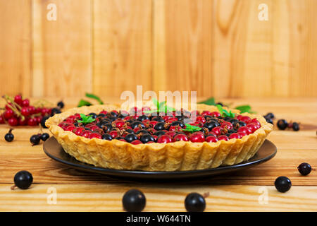 Köstliche Kuchen mit Pudding und Johannisbeeren auf hölzernen Hintergrund Stockfoto