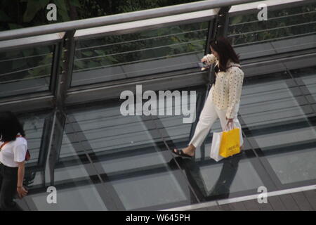 Besucher Spaziergang entlang eines Skywalk 20 Meter über dem Boden, nachdem Sie einen Monorail Bahn von Chongqing der Light Rail Linie 2 durch ein Wohngebiet Stockfoto