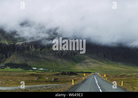 Schöne Landschaft Blick auf 1 Straße in Island mit Berge am Horizont und niedrige Wolken. Anreise mit dem Auto rund um Golden Circle von Island. Stockfoto