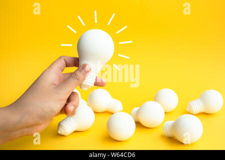Ideen inspiration Konzepte mit weibliche Hand, die eine Glühbirne auf pastellfarbenen Hintergrund. Business Kreativität. Teamwork für Brainstorming. Minimal Style. Stockfoto