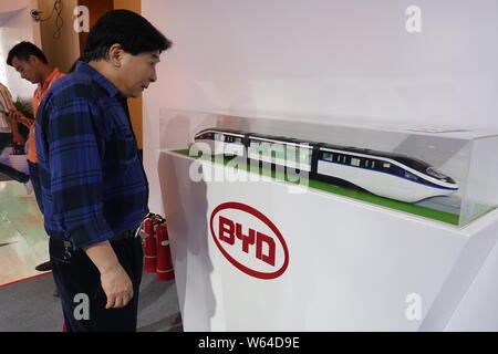 ---- Ein Besucher betrachtet ein Monorail Bahn Modell von kyRail" am Stand von elektrischen Automobilhersteller BYD während einer Ausstellung in Shanghai, China, 14 J Stockfoto