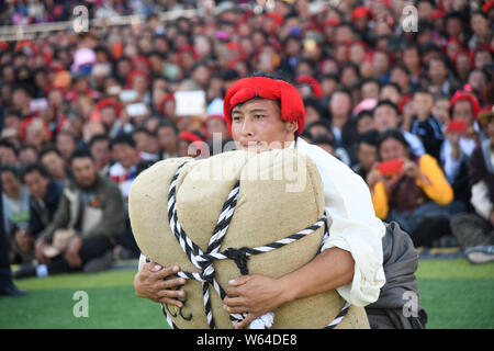 Ein Teilnehmer versucht, ein sandsack während eines starken Mannes Herausforderung in Markam County, Chamdo Stadt, im Südwesten Chinas Tibet autonomen Region, 4 Septem zu heben Stockfoto