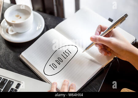 Aufgabenliste Konzepte mit Text in Notepad mit Kaffeetasse und Laptop im Cafe Hintergrund. Geschäftliche Motivation Strategie Konzepte Ideen. Stockfoto
