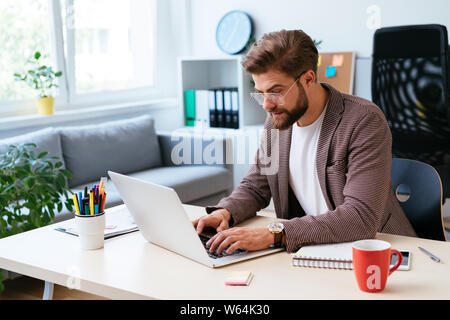 Junge startup Unternehmer Arbeiten am Laptop in der modernen Home Office. Portrait von Geschäftsmann während der Arbeit Stockfoto