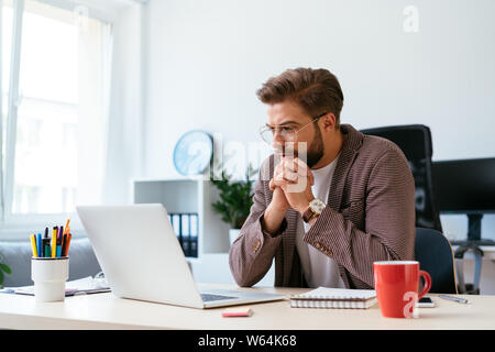Konzentrierte Geschäftsmann auf Laptop und analysieren. Porträt der jungen startup Unternehmer bei der Arbeit Stockfoto