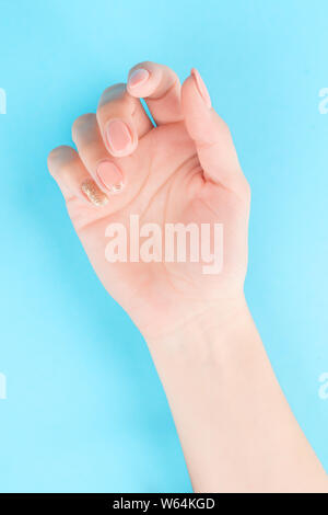 Hand mit rosa Nagellack. Auf blau, Beschneidungspfade getrennt ausgewiesen Stockfoto