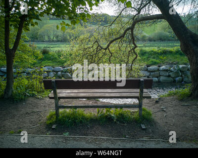 Sitzbank mit Blick auf den Fluss und die Felder auf der Pentewan Valley Trail Stockfoto