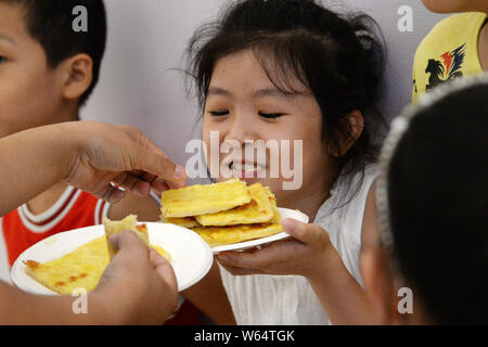 Personen teilen sich eine 16 Quadratmeter große Riesen Pizza im globalen Miller City Shopping Centre im Norden der Stadt Handan, Hebei Provinz Chinas, den 4. August 2018. Ein Stockfoto