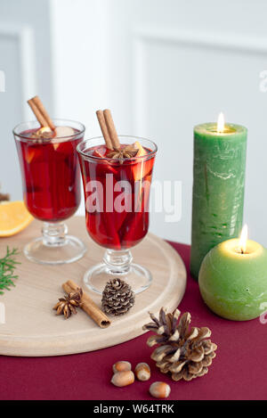 Zwei Gläsern Glühwein mit Zimt Sticks, ein trockenes Stück Orangen und Kegel, Stern auf einem weißen Tisch Anis Stockfoto