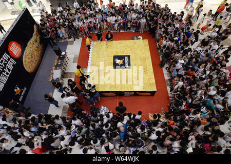 Personen teilen sich eine 16 Quadratmeter große Riesen Pizza im globalen Miller City Shopping Centre im Norden der Stadt Handan, Hebei Provinz Chinas, den 4. August 2018. Ein Stockfoto