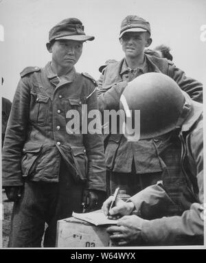 Bestürzung und Einsamkeit ist auf dem Gesicht dieses Jungen japanischen Mann geschrieben, trägt ein Nazi Uniform, in einer Zusammenfassung der deutschen Gefangenen an den Stränden von Frankreich. Der japanische Mann gibt seinen Namen und seine Nummer zu einem amerikanischen Armee Kapitän.; Allgemeine Hinweise: Verwenden Sie Krieg und Konflikt Nummer 1286 bei der Bestellung eine Reproduktion oder Anforderung von Informationen zu diesem Bild. Stockfoto