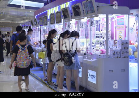 Die Spieler greifen Puppen auf gewöhnliche Puppe - grabbing Maschinen mit einer Shopping Mall in Shanghai, China, 7. August 2018. Ein 2-stöckiges riesigen menschlichen Puppe - ergreifende m Stockfoto