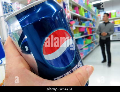 ---- Ein Kunde Geschäfte für eine Dose Pepsi Cola in einem Supermarkt in Shanghai, China, 27. Februar 2014. Am 2. August, PepsiCo Pläne angekündigt, Inc. Stockfoto