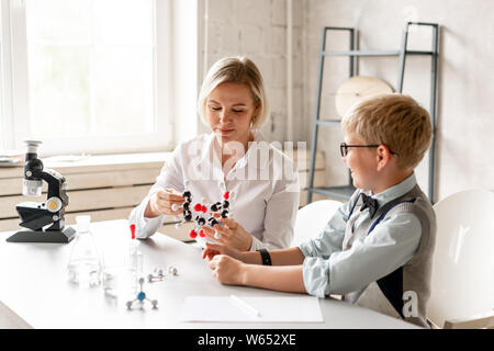 Junge Schüler aufmerksam Lektion seines Tutors der Chemie hören Stockfoto