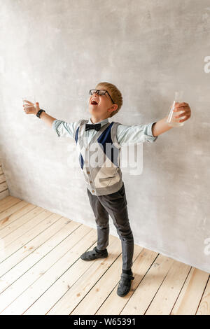 Junge mit schwarzen Hosen und weißen Pullover mit zwei Flaschen in den Händen posing Stockfoto