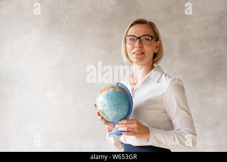 Charmante Lehrerin Bluse und Rock hält weltweit ihre Hände Stockfoto