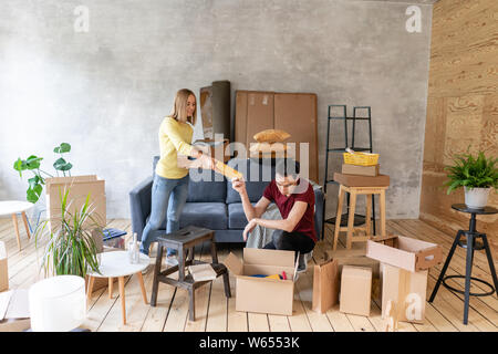 Glücklich lächelnde Paar Umzug in ein neues Haus und Auspacken der Kartons Kartons, Umzug und Renovierung Konzept Stockfoto