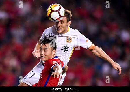 Kroatischer Fußballspieler Nikica Jelavic, oben, von Guizhou Hengfeng leitet den Ball gegen einen Spieler von Chongqing SWM in der 15. Runde während der Stockfoto