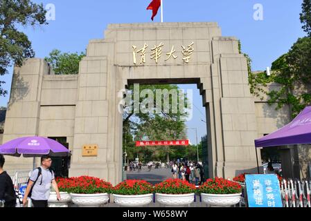 ---- Ein Fußgänger geht hinter einem Tor von der Tsinghua Universität in Peking, China, 26. April 2018. Absolventen von zwei Universitäten in Peking Stockfoto