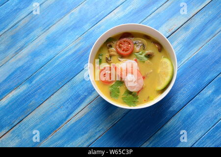 Tom Yam kung Würzige Suppe mit Garnelen, Meeresfrüchte, Tomaten, Pilze, Kokosmilch, Zitronengras, Ingwer und Chili Pfeffer in der Schüssel. Traditionelle thailändische Küche Stockfoto