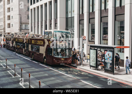 London, Großbritannien - 29 Juli, 2019: Zeile von oben offenen Big Bus Tour Busse auf einer Straße im Zentrum von London, selektive konzentrieren. London ist eine der meist besuchten Städte Stockfoto