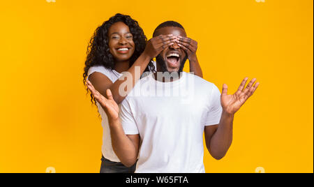 Fröhliche afro Girl ihr Freund die Augen von hinten Stockfoto