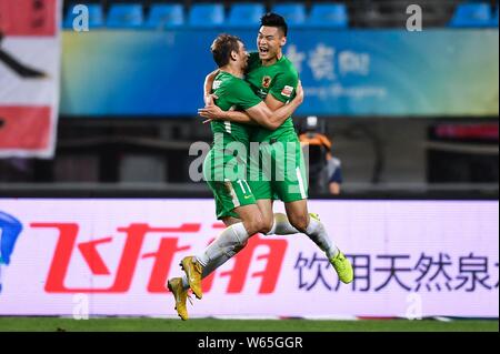 Kroatischer Fußballspieler Nikica Jelavic, links, von Guizhou Hengfeng feiert mit seinen Mannschaftskameraden Han Michael Wicke, nachdem er ein Ziel gegen Shandong Luneng Stockfoto