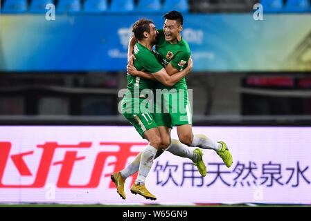 Kroatischer Fußballspieler Nikica Jelavic, links, von Guizhou Hengfeng feiert mit seinen Mannschaftskameraden Han Michael Wicke, nachdem er ein Ziel gegen Shandong Luneng Stockfoto