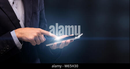 Geschäftsmann heraus halten, Finger auf Handy-Licht Stockfoto
