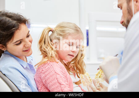 Pädiatrische Zahnarzt mit Mutter und Kind als Angst Patienten im Gespräch vor der Prüfung Stockfoto