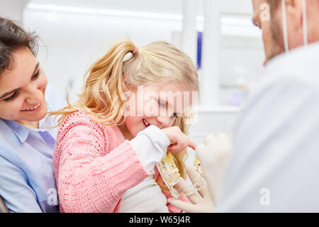 Pädiatrische Zahnarzt zeigt Mädchen eine Zahnprothese Modell vor der Prüfung in Kinderarzt Praxis Stockfoto