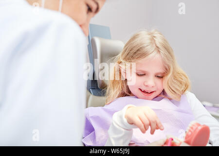 Kind als Patient schaut auf eine Prothese Modell an der forensischen Untersuchung mit einem medizinischen Assistenten Stockfoto