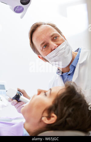 Patient erhält professionelle kosmetische Zähne, die der Zahnarzt in der Zahnarztpraxis Stockfoto