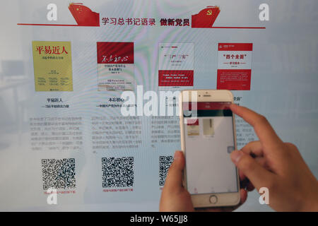 ---- Eine chinesische Mobiltelefon Benutzer scans QR-Code zum Download von e-Books und bereitet sich auf sein Smartphone an einem smart Bibliothek in der Stadt Xi'an, northwe zu lesen Stockfoto