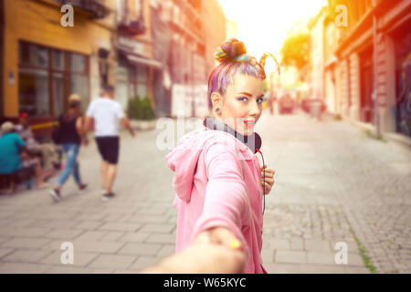 Happy and hipster Mädchen die Hand schauen hinter beim Gehen auf die Straße der Stadt - junge Frau mit Kopfhörer Spaß Reisen - funky smiling Stockfoto
