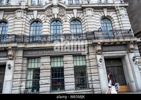 ---- Einen Fußgänger an einem Zweig der Landwirtschaftlichen Bank von China (ABC) am Bund im Huangpu District, Shanghai, China, 11. August 2018. Agric Stockfoto