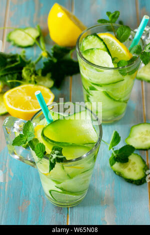 Gläser mit frischem organischen kalt und erfrischend infundiert detox Wasser mit Zitrone und Gurke auf Holztisch. Stockfoto