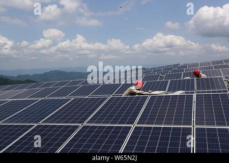 ------ Chinesische Arbeiter installieren Solaranlagen mit einer Photovoltaik- Kraftwerk in Qianjiang district, Chongqing, China, 27. Juli 2018. Wind- und Sonnenenergie e Stockfoto