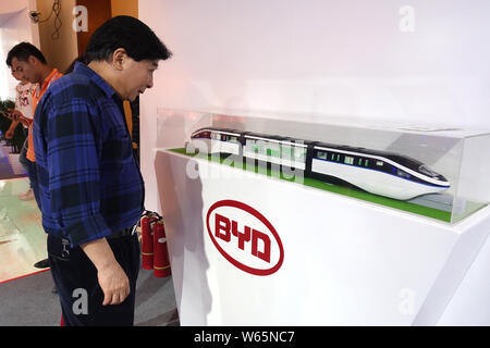 ---- Ein Besucher betrachtet ein Monorail Bahn Modell von kyRail" am Stand von elektrischen Automobilhersteller BYD während einer Ausstellung in Shanghai, China, 14 J Stockfoto