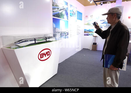 ---- Ein Besucher nimmt Fotos einer Monorail Bahn Modell von kyRail" am Stand von elektrischen Automobilhersteller BYD während einer Ausstellung in Shanghai, Kinn Stockfoto