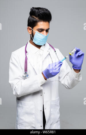 Indische Arzt männlichen Spritze mit Medizin auf weißem studio Hintergrund konzentriert Stockfoto