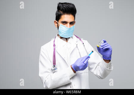 Indische Arzt männlichen Spritze mit Medizin auf weißem studio Hintergrund konzentriert Stockfoto