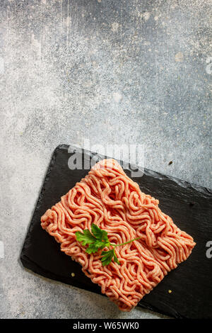 Frisches rohes Hackfleisch. Boden Hackfleisch auf Stein Schiefer Tafel. Ansicht von oben flach. Stockfoto