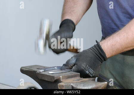 Hufschmied bei der Arbeit, Hufeisen in Form bringen. Stockfoto