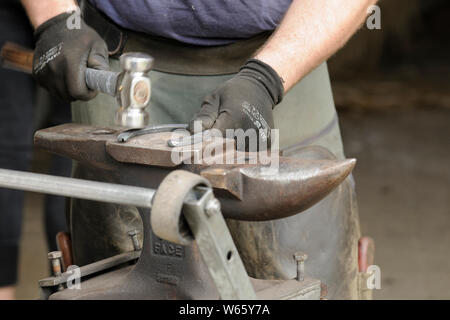 Hufschmied bei der Arbeit, Hufeisen in Form bringen. Stockfoto