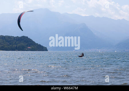 Comer see, Italien - Juli 21., 2019. Wasser sport: kitesurfer Surfen auf den Wellen der Wind auf die hellen sonnigen Sommertag in der Nähe der Colico, Stadt in Italien. Pomonto Stockfoto